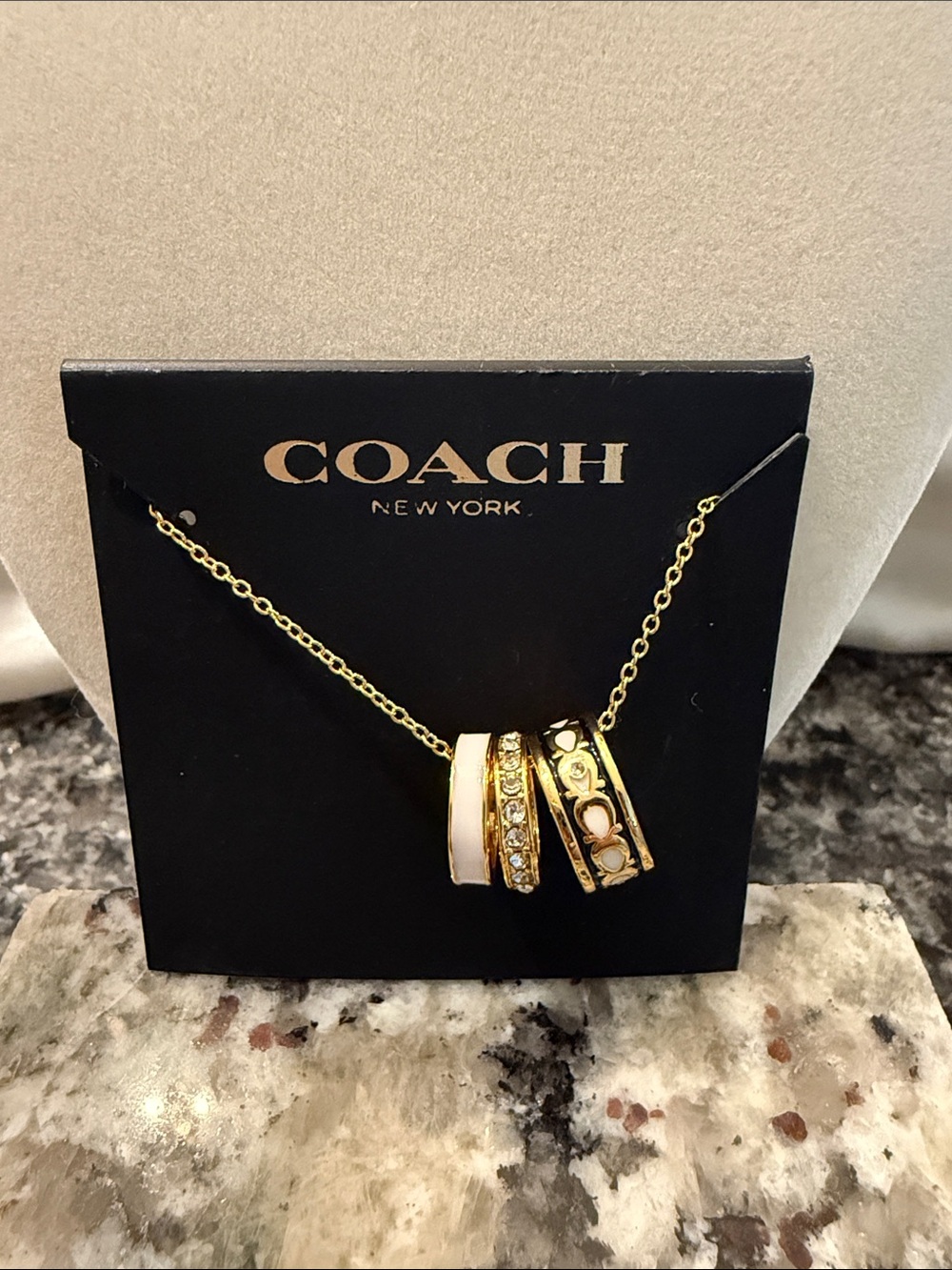 Coach Gold-Tone Ring Pendant Necklace with Cream and Black Accents
